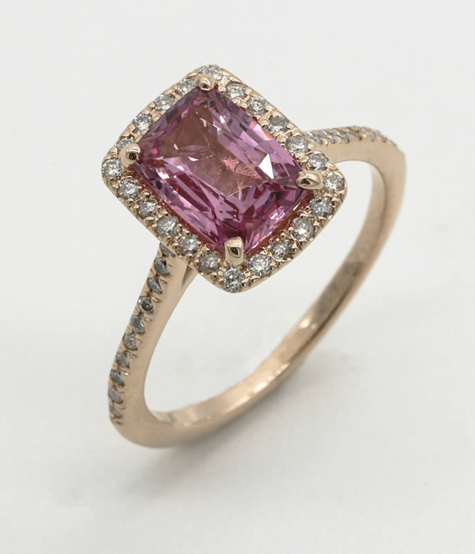 Pink gemstone ring with diamond accents on a gold band
